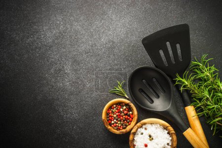 Foto de Kitchen utensils with food ingredients on black. Food background. Top view with copy space. - Imagen libre de derechos