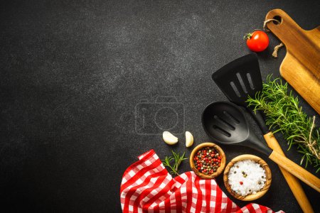 Téléchargez les photos : Food background. Kitchen utensils, wooden cutting board and food ingredients on black. Top view with copy space. - en image libre de droit