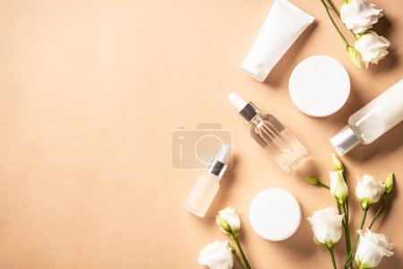 Photo for Natural cosmetic products. Cream, serum, tonic with green leaves and flowers. Skin care concept. Flat lay image with copy space. - Royalty Free Image
