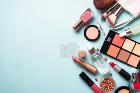 Téléchargez les photos : Make up cosmetics on blue background. Flat lay with copy space. - en image libre de droit