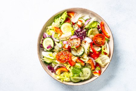 Foto de Vegan salad with green leaves, cucumber, paprika and tomatoes. Top view with copy space. - Imagen libre de derechos
