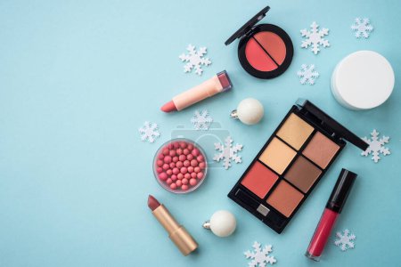 Foto de Maquillaje de productos y decoraciones de Navidad sobre fondo azul. Compras de vacaciones. Imagen plana con espacio de copia. - Imagen libre de derechos