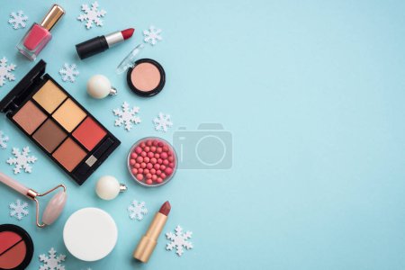 Foto de Cosmética de invierno. Maquillaje de productos y decoraciones de Navidad sobre fondo azul. Imagen plana con espacio de copia. - Imagen libre de derechos