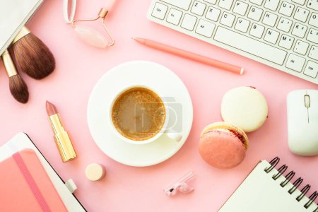 Téléchargez les photos : Home office workspace. Creative Pink flat lay background with keyboard, notebook, coffee cup and cosmetics.. - en image libre de droit