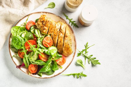 Photo for Green salad with chicken fillet on white. Healthy food. Top view with copy space. - Royalty Free Image