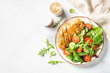 Téléchargez les photos : Fresh salad with chicken fillet and vegetables on white. Top view with copy space. - en image libre de droit