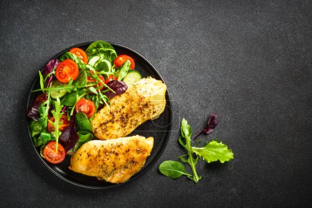 Photo for Healthy food plate, keto diet. Green salad with chicken fillet on black table. Top view with copy space. - Royalty Free Image