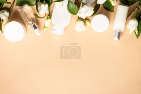 Photo for Natural cosmetic products. Cream, serum, tonic with green leaves and flowers. Flat lay image with copy space. - Royalty Free Image