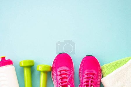 Foto de Fitness background, healthy lifestyle concept. Dumbbells, sneakers, towel and water bottle top view. - Imagen libre de derechos