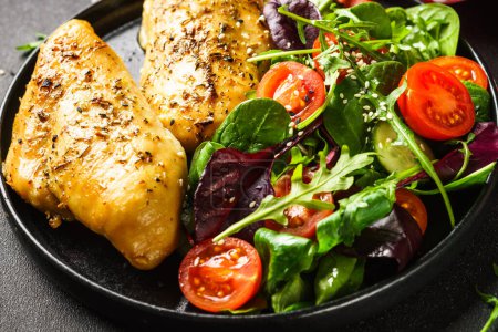 Téléchargez les photos : Healthy food plate, keto diet. Green salad with chicken fillet on black. - en image libre de droit