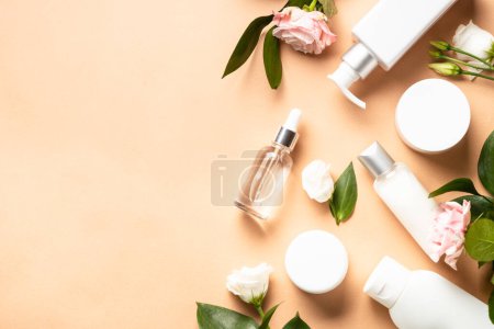Téléchargez les photos : Natural cosmetic products. Cream, serum, tonic with green leaves and rose flowers. Scin care concept, anti aging. - en image libre de droit