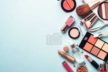 Foto de Make up cosmetics on blue background. Flat lay with copy space. - Imagen libre de derechos