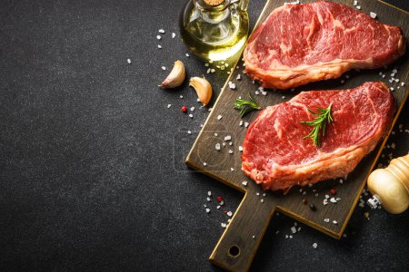 Téléchargez les photos : Steak de boeuf aux épices. Viande de bœuf crue au noir. Image vue du dessus. - en image libre de droit