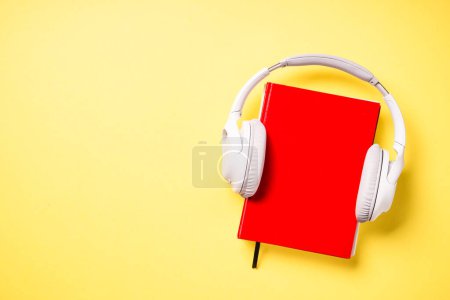 Foto de Concepto de audiolibros. Auriculares y libros de fondo amarillo. Escucha, estudio, podcast. - Imagen libre de derechos