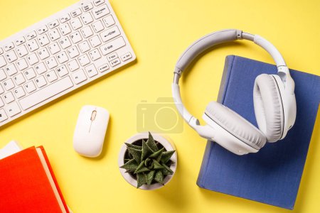 Foto de Office desk with headphones, notepad and pen at color background. Flat lay image with copy space. Office, studying, workspace. - Imagen libre de derechos