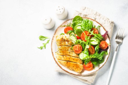 Photo for Green salad with chicken fillet on white. Diet food, healthy nutrition. Top view with copy space. - Royalty Free Image