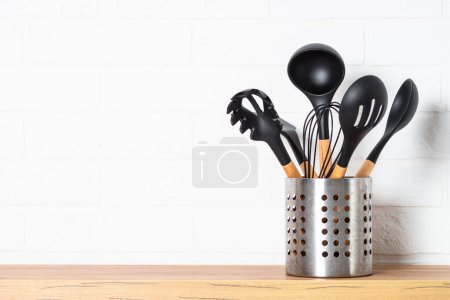 Foto de Utensilios de cocina, utensilios de cocina en recipiente de metal cerca de la pared blanca. - Imagen libre de derechos