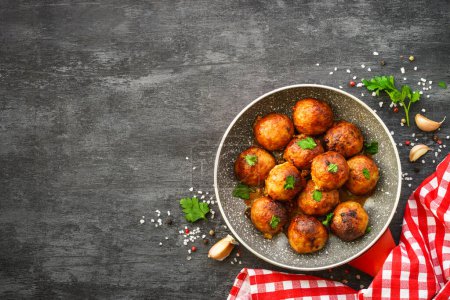 Photo for Meatballs in tomato sauce with herbs at dark table. Flat lay image with space for text. - Royalty Free Image