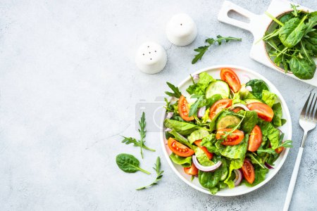 Photo for Fresh green salad with leaves and vegetables. Top view with copy space at stone table. - Royalty Free Image