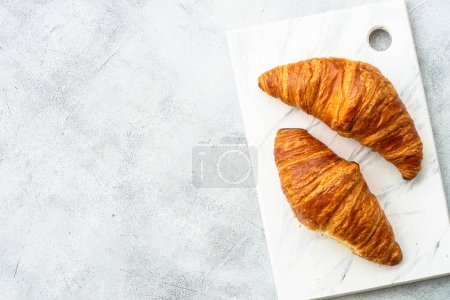 Photo for Croissant on cutting board at white table top view. French bakery. - Royalty Free Image