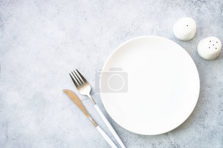 Photo for White plate and modern cutlery at stone table. Table setting, Flat lay image. - Royalty Free Image