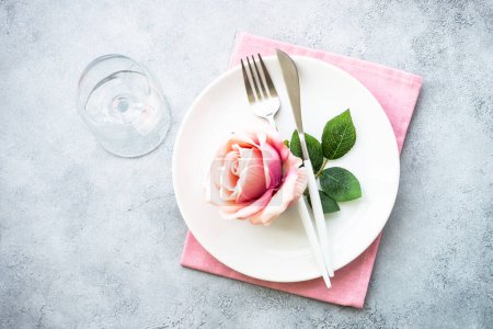 Photo for Faestive Table setting with white plate and rose flowers. Table decor for an anniversary or wedding. Flat lay with copy space. - Royalty Free Image