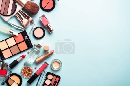 Téléchargez les photos : Maquiller des produits cosmétiques sur fond bleu. Image de pose plate avec espace de copie. - en image libre de droit