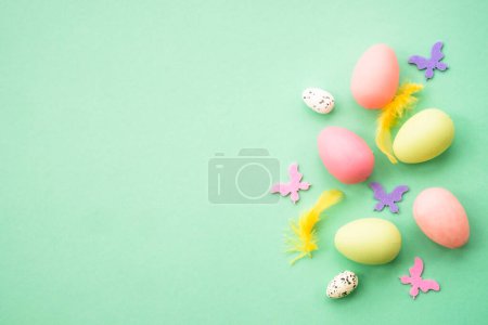 Photo for Happy Easter background with colored eggs and butterflies. Flat lay image at green. - Royalty Free Image