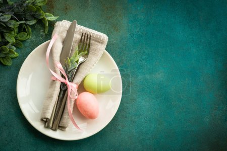 Téléchargez les photos : Table de Pâques, fond alimentaire de Pâques. Assiette blanche avec couverts, œufs, fleurs de printemps et papillon. Pose plate avec espace de copie. - en image libre de droit