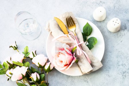 Téléchargez les photos : Table de printemps avec assiette blanche et fleurs roses. Décor de table pour un anniversaire ou un mariage. Pose plate avec au blanc. - en image libre de droit