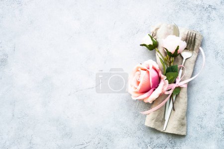Foto de Mesa de Primavera con cubertería moderna y flores de rosas. Vista superior con espacio de copia. - Imagen libre de derechos