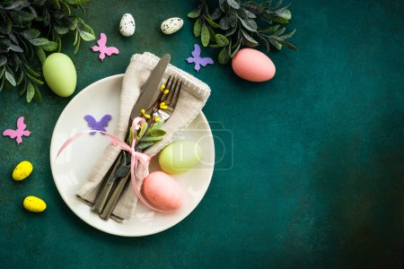 Téléchargez les photos : Fond alimentaire de Pâques. Table de printemps. Assiette blanche avec couverts décor de Pâques. Pose plate avec espace de copie. - en image libre de droit
