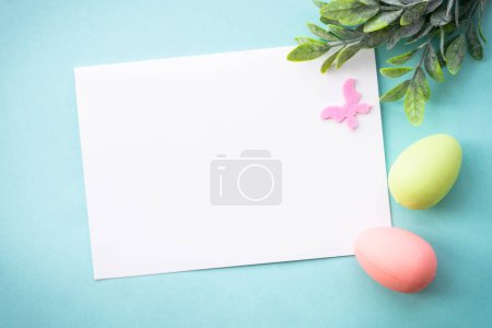 Téléchargez les photos : Fond de Pâques ou carte de vœux sur bleu. Œufs, feuilles de printemps et papillons. Pose plate avec espace de copie. - en image libre de droit