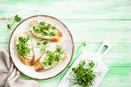 Photo for Open sandwich with cream cheese and micro greens at green background. Natural Healthy food, natural vitamins. Top view with copy space. - Royalty Free Image
