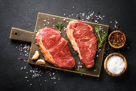 Téléchargez les photos : Beef steak. Raw beef meat at black. Top view with copy space. - en image libre de droit