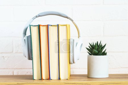 Téléchargez les photos : Audio books concept. Wireless Headphones and color books at table white background. - en image libre de droit