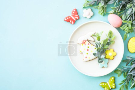 Foto de Fondo de comida de Pascua. Plato blanco con huevos, flores de primavera y galletas de Pascua. Puesta plana. - Imagen libre de derechos