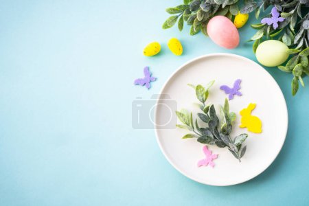 Téléchargez les photos : Table de Pâques, fond alimentaire de Pâques. Assiette blanche avec œufs et décorations de vacances. Vue supérieure avec espace de copie. - en image libre de droit