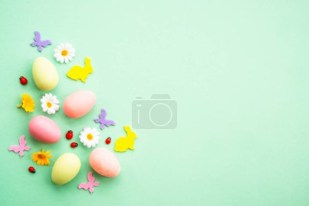 Foto de Fondo de Pascua. Huevos, conejo, flores de primavera y mariposa. plano se burlan de la mentira en el fondo verde. - Imagen libre de derechos