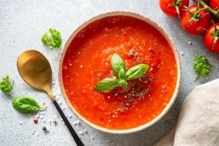 Téléchargez les photos : Soupe de tomates sur table en pierre claire. Plat végétalien. Vue de dessus sur table en pierre claire. - en image libre de droit