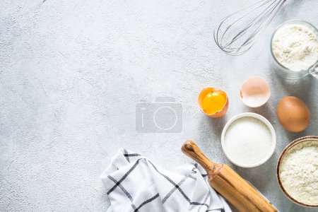Photo for Baking background ingredients. Flour, sugar, eggs and others at light stone table. Top view with copy space. - Royalty Free Image