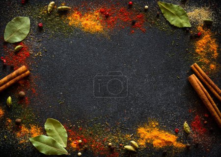 Photo for Spices and herbs on black slate background. Pepper, turmelic, dill, cinnamon, basil, rosemary, chilly, cardamom. Top view with copy space. - Royalty Free Image