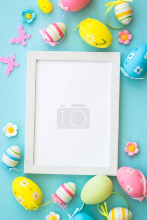 Téléchargez les photos : Carte de vœux de Pâques sur bleu. Œufs de Pâques colorés avec décorations et cadre blanc pour le texte. Vertical. - en image libre de droit