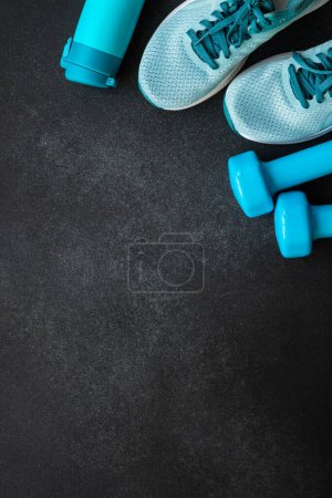 Photo for Sneakers, dumbbels and water bottle at black background. Workout and fitness concept. Top view. - Royalty Free Image