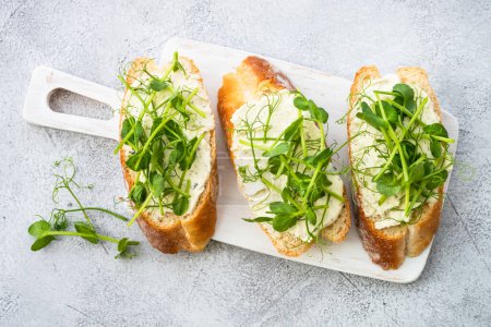 Photo for Toast with cream cheese and micro greens at cutting board. Healthy food, vegetarian dish. - Royalty Free Image