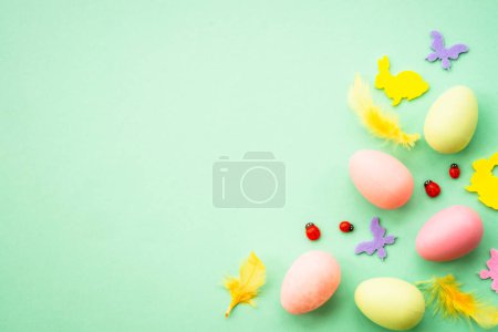 Foto de Fondo de Pascua. Huevos, conejo, flores de primavera y mariposa. plano se burlan de la mentira en el fondo verde. - Imagen libre de derechos