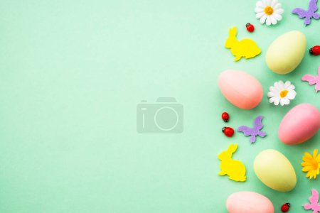 Foto de Feliz Pascua con huevos de colores y mariposas. Imagen de laico plano en verde. - Imagen libre de derechos