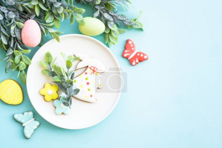 Foto de Fondo de comida de Pascua. Plato blanco con huevos, flores de primavera y galletas de Pascua. Puesta plana. - Imagen libre de derechos