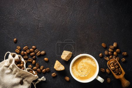 Foto de Coffee cup and coffee beans at dark table . Top view image with copy space. - Imagen libre de derechos