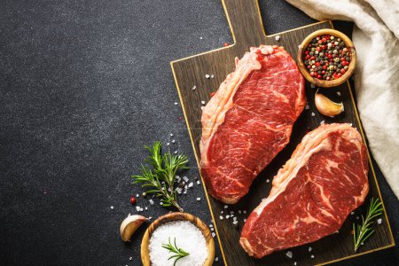 Téléchargez les photos : Beef steak. Raw beef meat at black. Top view with copy space. - en image libre de droit
